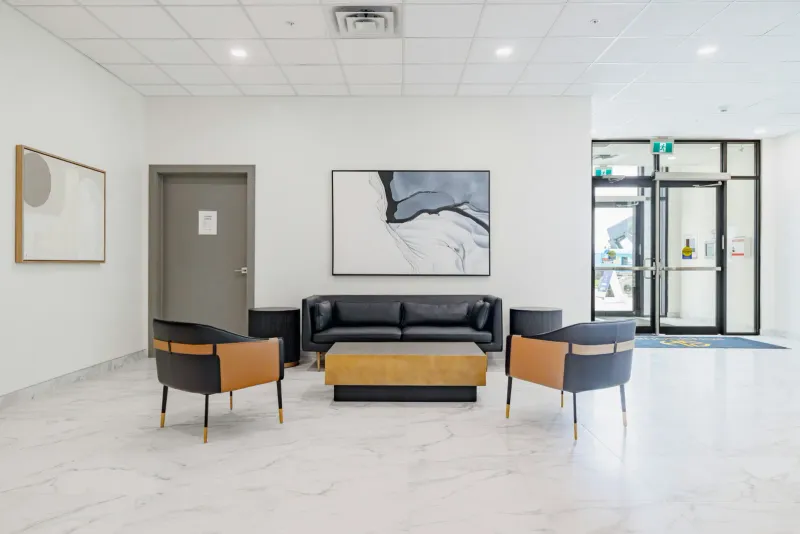 A bright, modern medical clinic reception lounge with leather seating and contemporary artwork