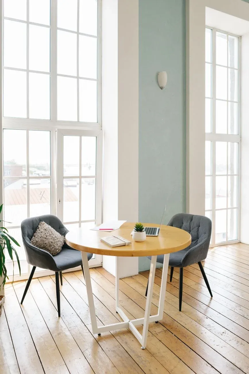 A bright minimal meeting nook with timber floors and a rooftop view