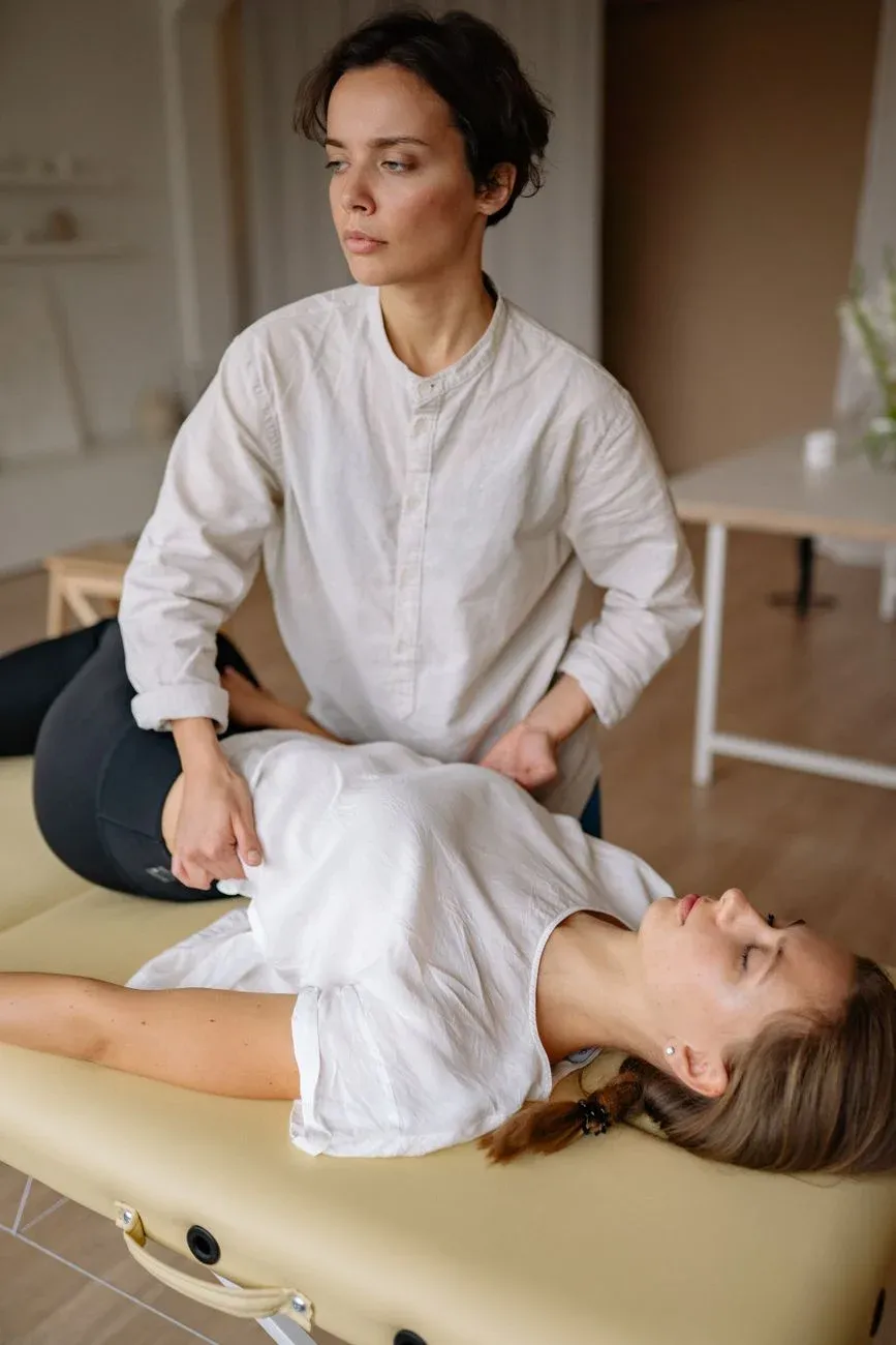 A practitioner performing a hands-on spinal treatment in a warm, naturally lit clinic