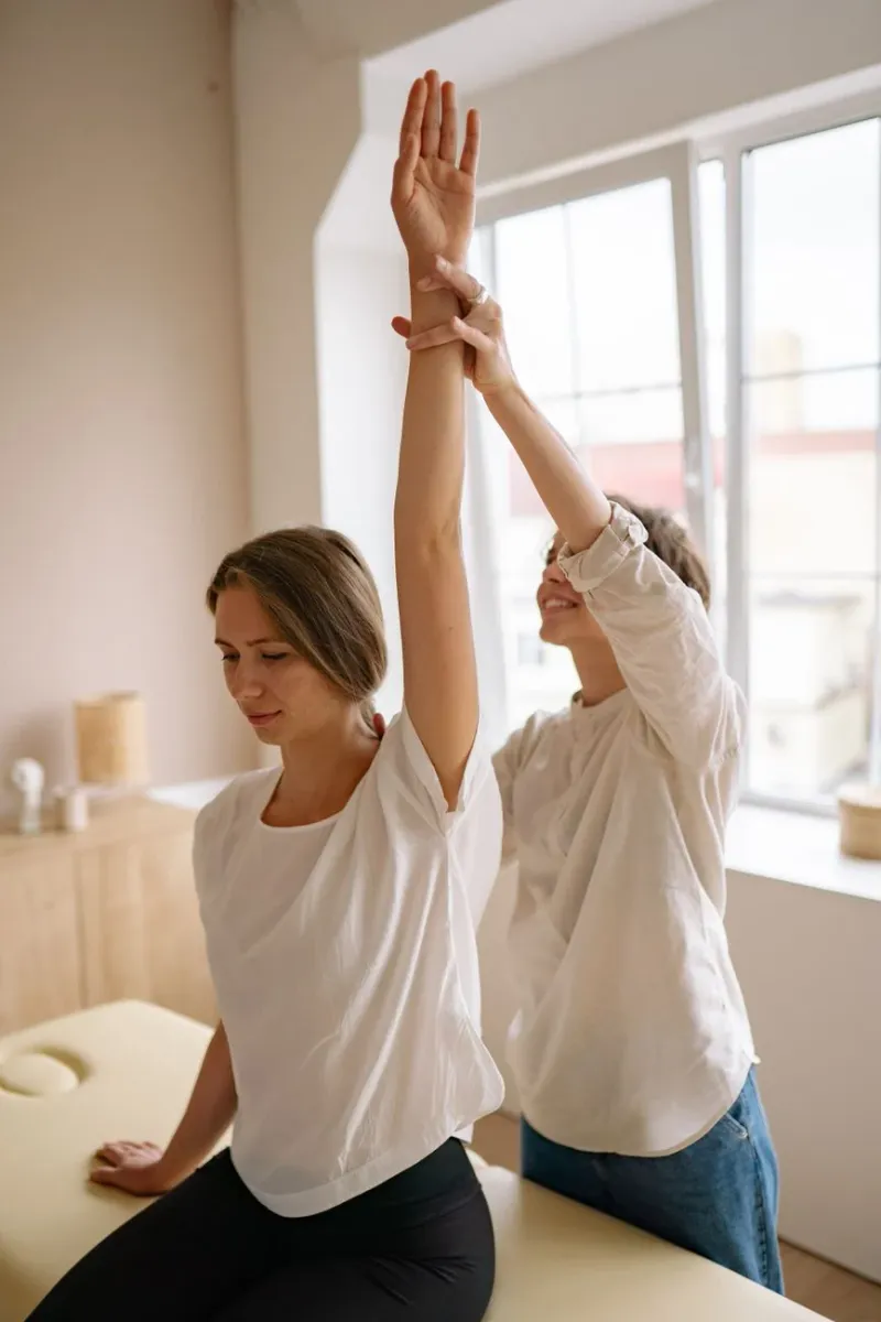A woman stretching by a bright window in a calm room