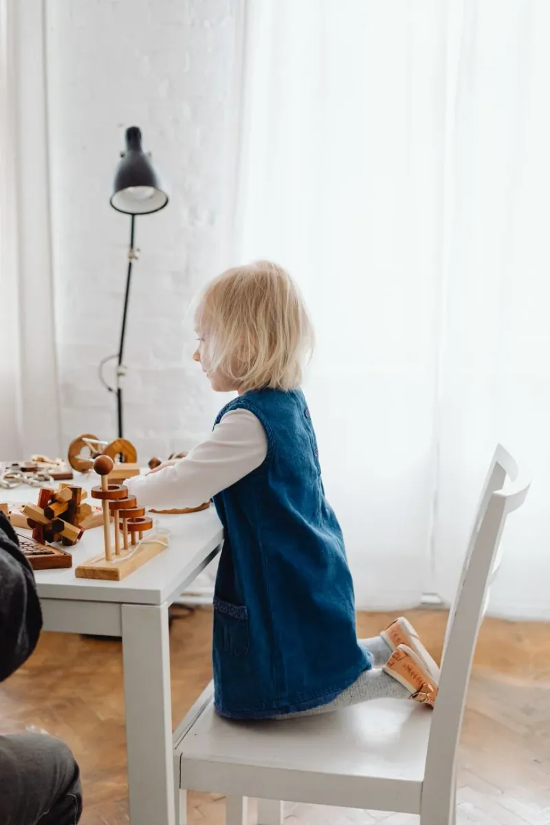 A child playing at a table in soft natural light